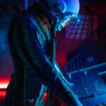 Side view of an astronaut in a futuristic, illuminated space setting, operating controls.