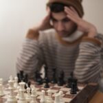 a man sitting at a table with a chess board