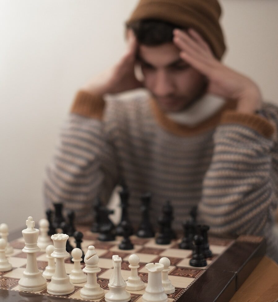 a man sitting at a table with a chess board